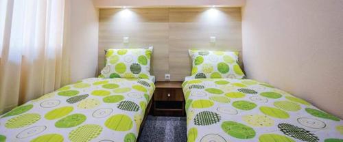 トラヴニクにあるMotel Calypso Travnikのベッドルーム1室(隣り合わせのベッド2台付)