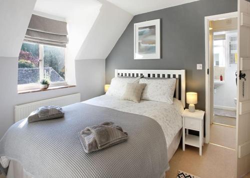 um quarto com uma cama e uma janela em Character Snowshill Cottage - 2 Glebe Cottage’s em Snowshill