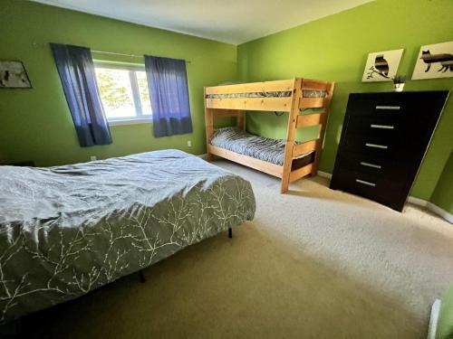 5 Star Denali Park Spacious Family Home في هيلي: غرفة نوم بجدران خضراء وسرير بطابقين