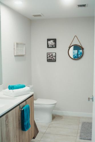 a bathroom with a toilet and a sink and a mirror at Luxury Oceanview Studio at Miami Design District in Miami