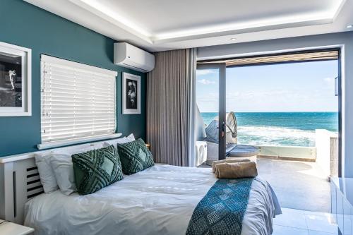 Schlafzimmer mit einem Bett und Meerblick in der Unterkunft Luxurious 3 bedroom beach front apartment in Ballito