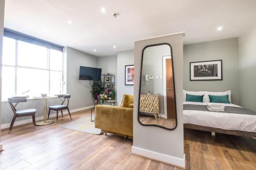 een slaapkamer met een bed, een spiegel en een bureau bij Host & Stay - The Georgian Quarters at Bedford in Liverpool