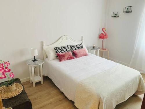 a bedroom with a white bed with pink pillows at Apartamento Ruiz Zorrilla in Santander