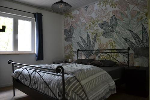 una camera da letto con un letto e carta da parati floreale di Le Chalet du Gégé a Bouillon