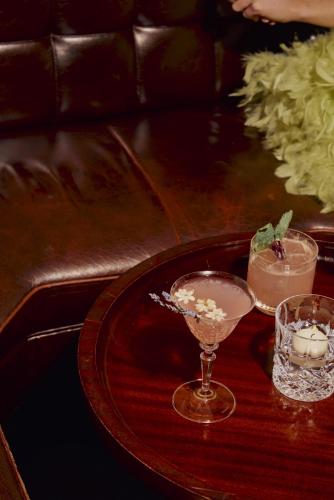 a wooden table with two glasses and candles on it at St Martins Lane London in London