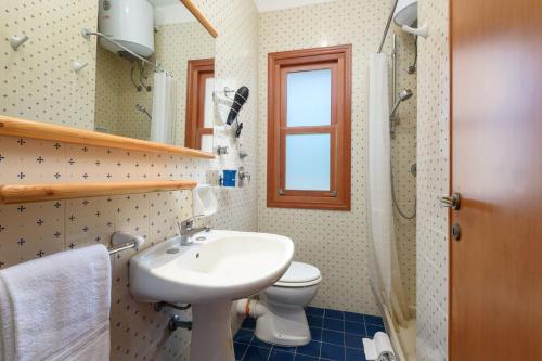 baño con lavabo y aseo y ventana en Casa ChiaraMarina, en Macari