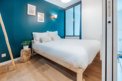 ein Schlafzimmer mit einem großen Bett mit blauer Wand in der Unterkunft Vieux Lille Village Cottage in Lille