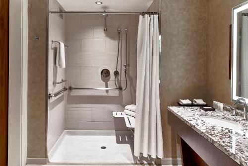 a bathroom with a shower and a tub and a sink at Renaissance Atlanta Midtown Hotel in Atlanta