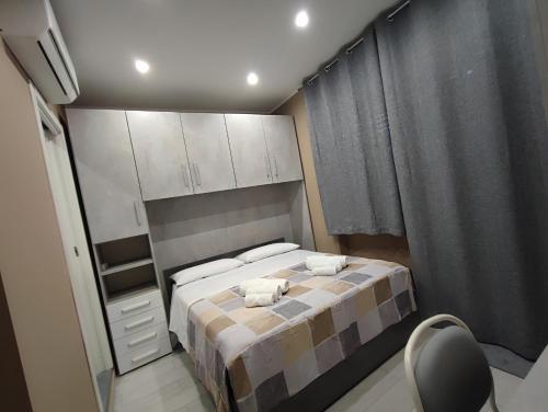 a bedroom with a bed with two towels on it at BOLANO HOUSE in Catania