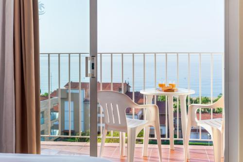 2 Stühle und ein Tisch auf einem Balkon mit Meerblick in der Unterkunft Checkin Catalonia in Calella