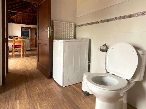 bagno con servizi igienici bianchi e frigorifero. di Casa Demetria La Palma a Puntagorda