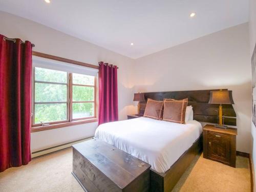 a bedroom with a bed and a large window at Plateau 202-5/STUNNING 3bdr with POOL in Mont-Tremblant