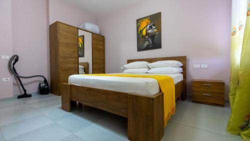 a bedroom with a large bed with a yellow blanket at Miloen Residence Gjiri I Lalzit in Draç