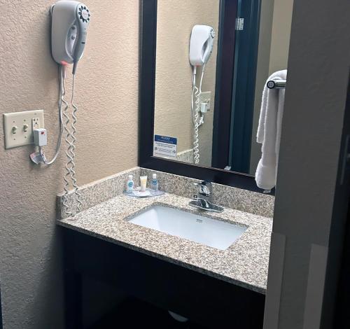 a bathroom sink with a phone and a mirror at Comfort Inn & Suites Evansville Airport in Evansville