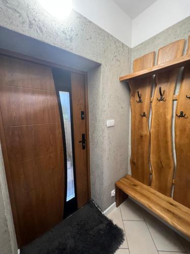 Pokój z 2 drewnianymi szafkami i drzwiami w obiekcie APARTAMENT PIEKOSZOWSKA Targi Domek Parking w Kielcach