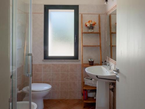 オルビアにあるLa Casa di Alice Turcheseのバスルーム(トイレ、洗面台付)、窓が備わります。