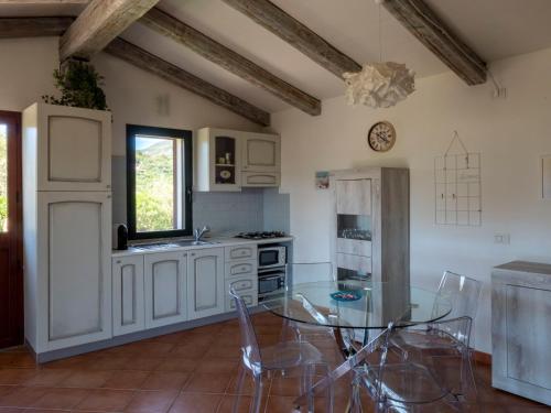オルビアにあるLa Casa di Alice Turcheseのガラスのテーブル付きのキッチンが備わる客室です。