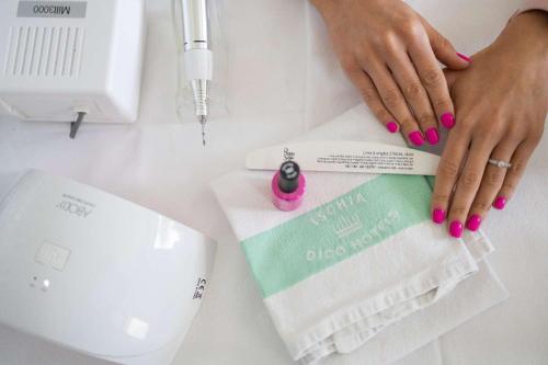 a woman with pink nail polish holding a book on a counter at Hotel Royal Terme in Ischia