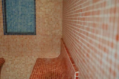 a tiled shower with a bench in a bathroom at Hotel Royal Terme in Ischia