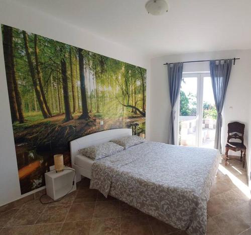 a bedroom with a bed with a painting on the wall at Villa AveKalu in Opric