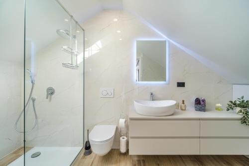 a white bathroom with a sink and a shower at Villa Celeste in Supetar