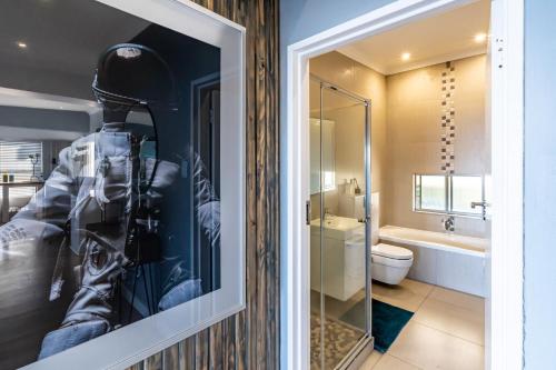 ein Badezimmer mit einer Glastür mit einem Mann im Anzug in der Unterkunft Beach front penthouse apartment in Ballito
