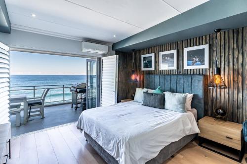 1 Schlafzimmer mit einem Bett und einem Balkon mit Meerblick in der Unterkunft Beach front penthouse apartment in Ballito