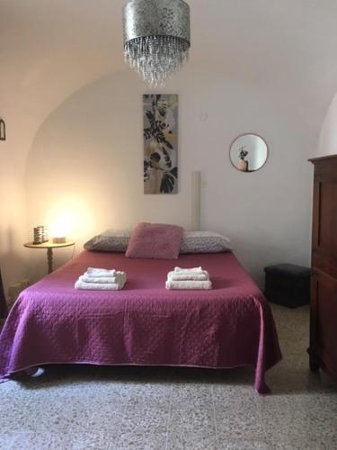 a bedroom with a purple bed with two towels on it at Da Julia in Oristano