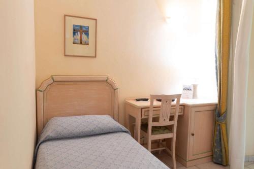 a bedroom with a bed and a desk with a chair at Hotel Royal Terme in Ischia
