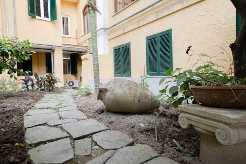 a garden with a stone walkway in front of a building at Hotel Royal Terme in Ischia