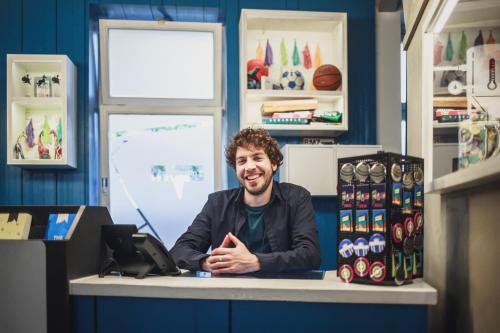 a man sitting at a counter in a store at The Circus Hostel in Berlin