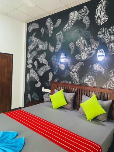 - une chambre avec un lit doté d'oreillers jaunes et bleus dans l'établissement thambara gueust house, à Habarana