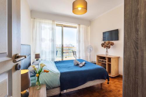 une chambre avec un lit bleu et une fenêtre dans l'établissement GRAND SOLEIL AP4365 By Riviera Holiday Homes, à Nice