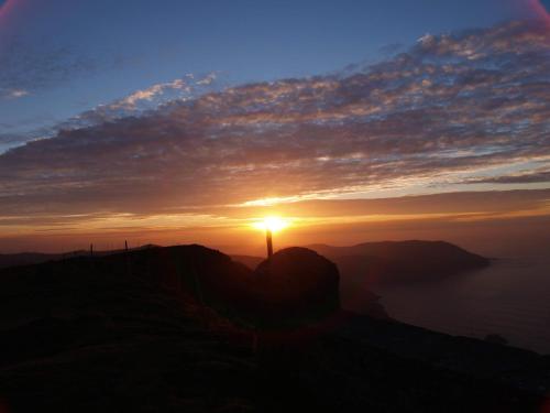 a sunset on top of a mountain with the sun setting at Paraíso Ortegal in Feás