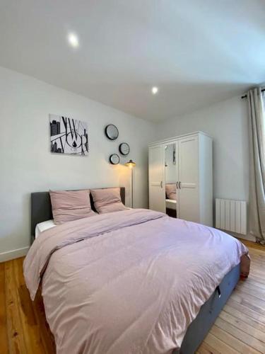 - une chambre avec un grand lit et des draps roses dans l'établissement Le New York Appart' T1 Bis au centre du MANS, au Mans