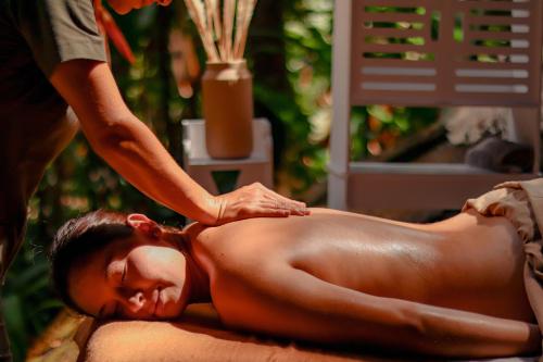 uma mulher a receber uma massagem às costas de um terapeuta em Jardines Secretos em Rivas