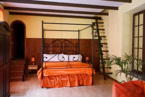 um quarto com uma cama com uma colcha laranja em Hotel Rural Villa del Monte em Santa Brígida