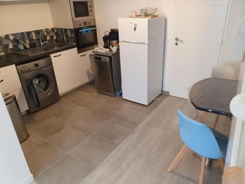 Il comprend une cuisine équipée d'un réfrigérateur, d'une table et d'une chaise. dans l'établissement Kelveine, au Pouliguen