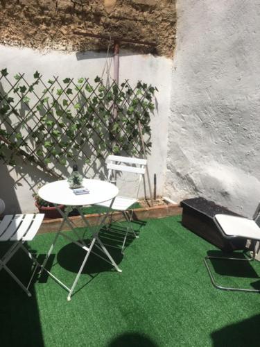 una stanza con tavolo, sedie e erba verde di Da Julia a Oristano