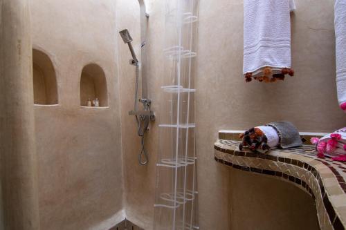 una doccia in un bagno con box doccia in vetro di Riad Dar Oulhoum a Marrakech