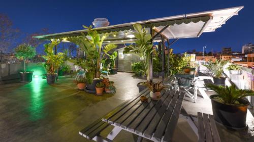 a patio with a bench and potted plants on a roof at Monastiraki Factory Living- Unspoiled Athens Apartments in Athens