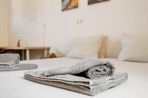 a pile of towels sitting on top of a bed at Local Guesthouse in Sagres