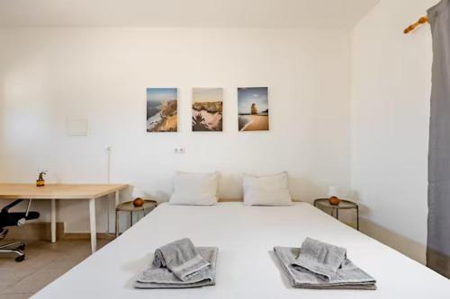 1 dormitorio con cama blanca y escritorio en Local Guesthouse en Sagres