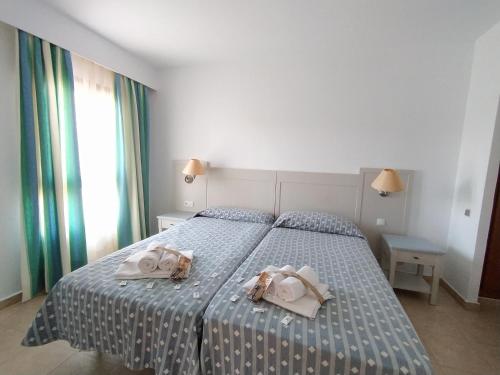 a bedroom with a bed with two towels on it at APARTAMENTO DE UN DORMITORIO PRIMERA PLANTA in Ayamonte