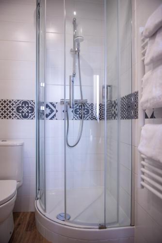 une douche avec une porte vitrée dans une salle de bain dans l'établissement Hôtel Istria by Magna Arbor, à Paris