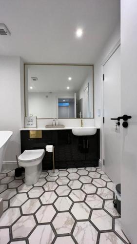 uma casa de banho com um lavatório, um WC e um espelho. em Morelli Plaza Portstewart em Portstewart