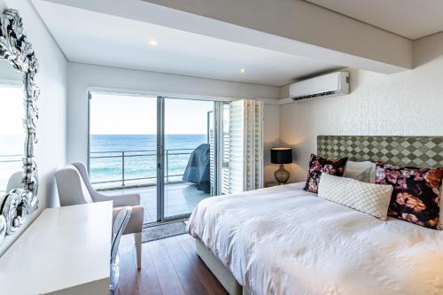 Modern Beach Front Apartment في باليتو: غرفة نوم مع سرير وإطلالة على المحيط