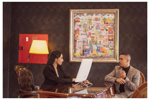 a man and woman sitting at a table with a laptop at Sky Casa Airport in Nouaseur