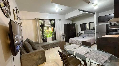een woonkamer met een bank, een bed en een tafel bij Manhattan Parkview studio unit in Manilla