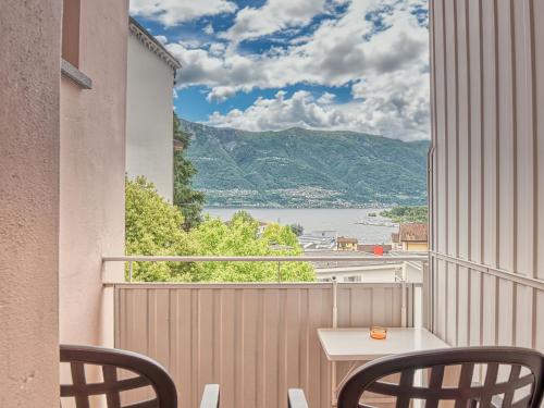 ロカルノにある@ Home Hotel Locarnoの水辺の景色を望むバルコニー(テーブル、椅子付)